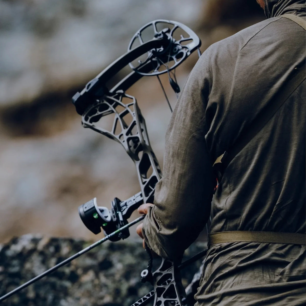 Guy in field holding compound bow